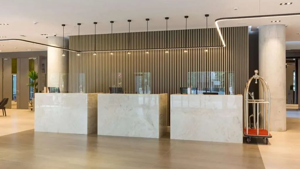 Protective sneeze guards placed on hotel reception welcome desk
